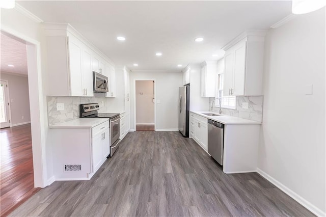 kitchen with appliances with stainless steel finishes, a sink, healthy amount of natural light, baseboards, and recessed lighting