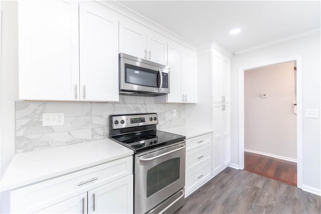 kitchen featuring stainless steel appliances, white cabinetry, dark wood-style floors, decorative backsplash, and light countertops