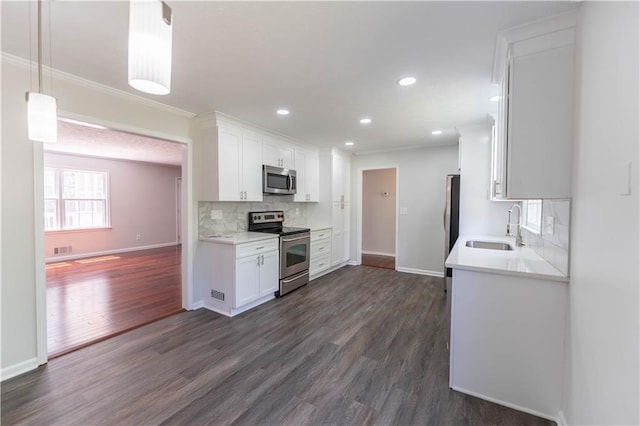 kitchen with appliances with stainless steel finishes, a sink, baseboards, ornamental molding, and backsplash
