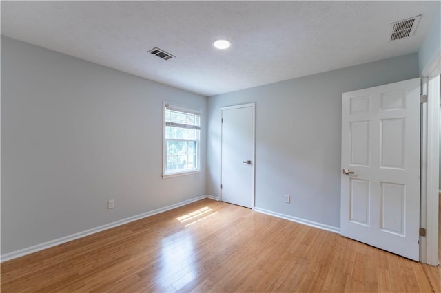 unfurnished bedroom with light wood-style flooring, baseboards, recessed lighting, and a closet