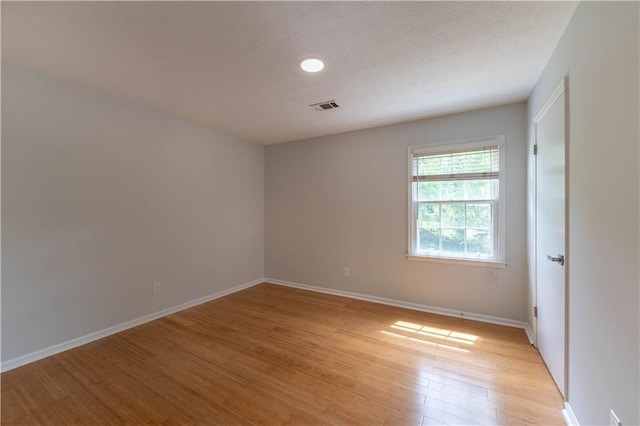 empty room featuring light wood finished floors and baseboards