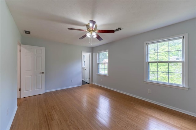 empty room featuring baseboards, a ceiling fan, and wood finished floors