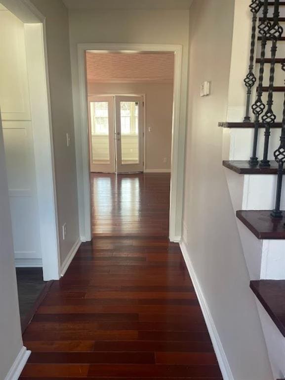 hall featuring baseboards, wood finished floors, and french doors