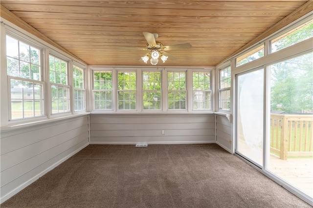 unfurnished sunroom with wood ceiling, plenty of natural light, and carpet