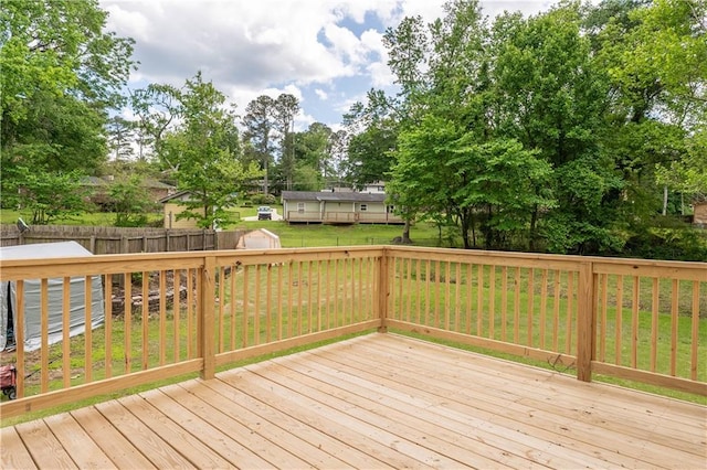deck with a shed and view of wooded area