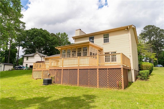 back of property featuring a deck, a yard, a chimney, and central AC