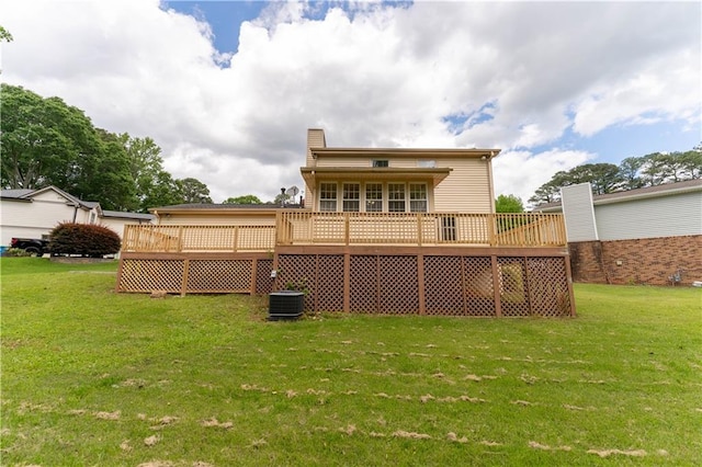 rear view of property with a yard, a wooden deck, a chimney, and cooling unit