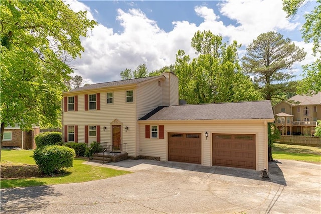 colonial house featuring driveway and an attached garage