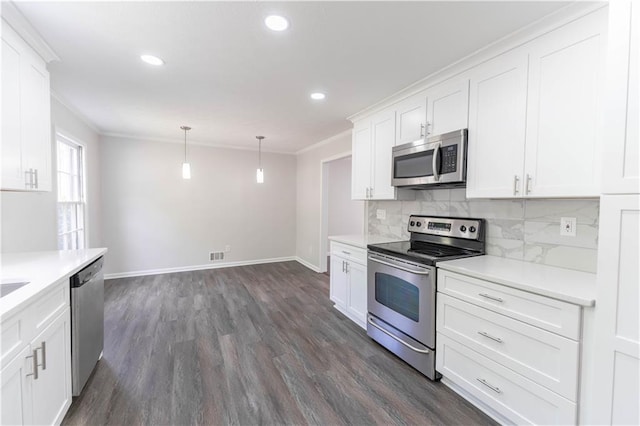 kitchen with appliances with stainless steel finishes, ornamental molding, dark wood-style floors, white cabinetry, and tasteful backsplash