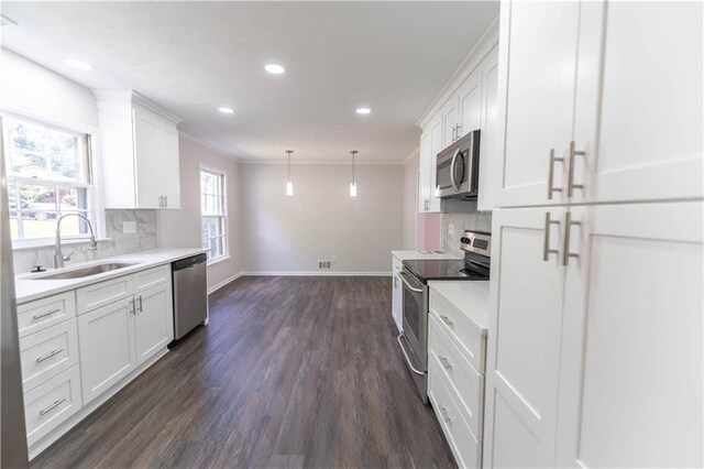 kitchen featuring appliances with stainless steel finishes, a sink, decorative backsplash, dark wood finished floors, and recessed lighting