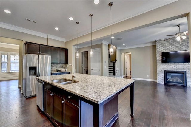 12095 Cameron Dr, Duluth, GA 30097 - kitchen featuring a sink, stainless steel appliances, a brick fireplace, ceiling fan, and light stone counters