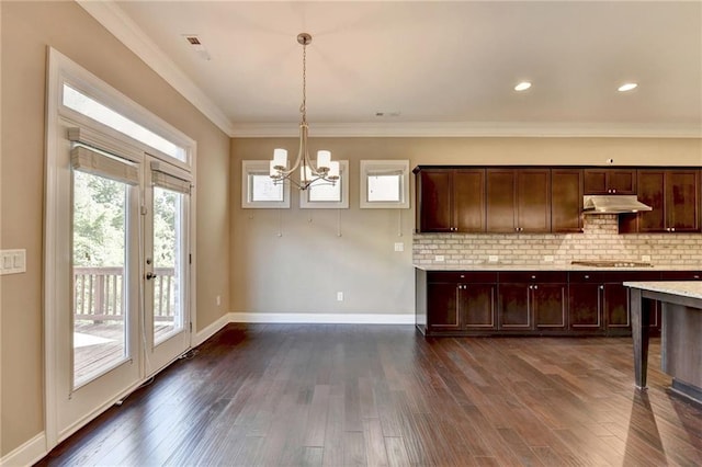 12095 Cameron Dr, Duluth, GA 30097 - kitchen with under cabinet range hood, a chandelier, light countertops, dark wood-style floors, and backsplash