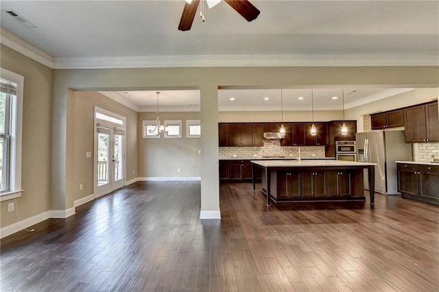 12095 Cameron Dr, Duluth, GA 30097 - kitchen featuring stainless steel fridge, light countertops, plenty of natural light, dark brown cabinets, and crown molding