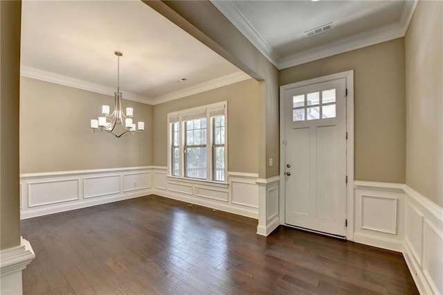 12095 Cameron Dr, Duluth, GA 30097 - entryway featuring healthy amount of natural light, a chandelier, dark wood finished floors, a wainscoted wall, and ornamental molding