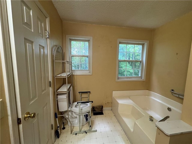 134 Summer Lake Dr, Dallas, GA 30157 - bathroom featuring a garden tub, tile patterned floors, a textured ceiling, and baseboards
