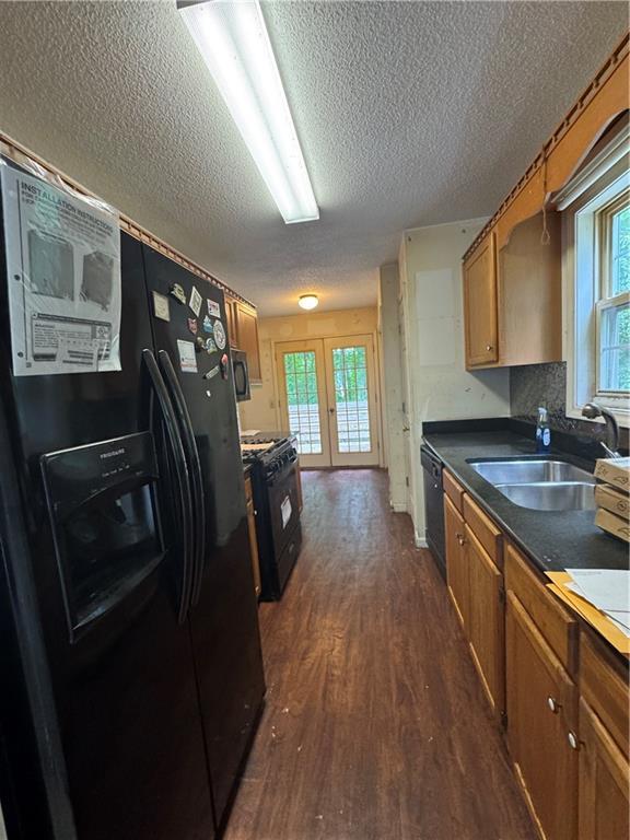 134 Summer Lake Dr, Dallas, GA 30157 - kitchen featuring a sink, black appliances, a textured ceiling, dark wood-style floors, and brown cabinets
