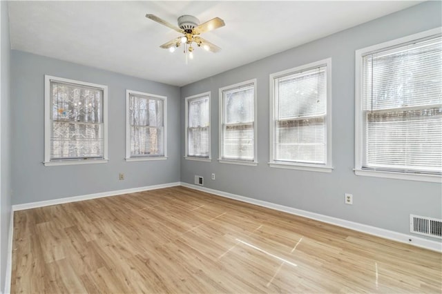 unfurnished room featuring visible vents, light wood-type flooring, and baseboards