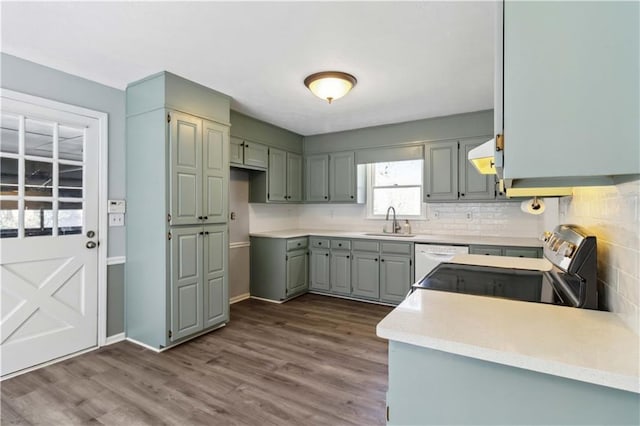 kitchen with gray cabinetry, dark wood finished floors, dishwasher, electric stove, and a sink