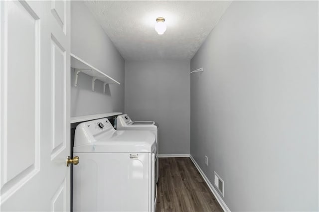 washroom featuring independent washer and dryer, a textured ceiling, dark wood finished floors, baseboards, and laundry area