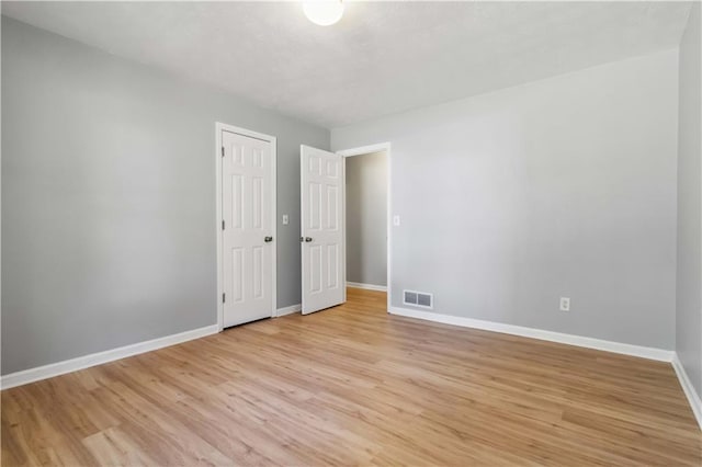 interior space with light wood-style floors, visible vents, and baseboards