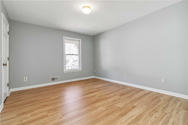 unfurnished room featuring baseboards, visible vents, and light wood finished floors