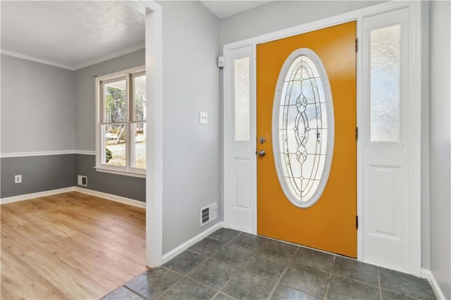 foyer featuring visible vents, baseboards, and ornamental molding