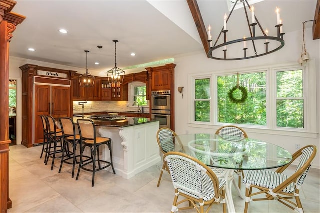 210 Hunters Vw, Roswell, GA 30075 - kitchen featuring appliances with stainless steel finishes, a chandelier, dark countertops, decorative backsplash, and a kitchen breakfast bar