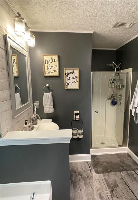 40 Legend Creek Chase, Douglasville, GA 30134 - bathroom featuring a stall shower, a textured ceiling, vanity, wood finished floors, and baseboards