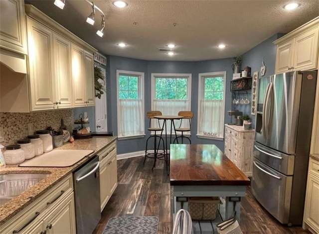 40 Legend Creek Chase, Douglasville, GA 30134 - kitchen with stainless steel appliances, dark wood finished floors, light stone counters, healthy amount of natural light, and a textured ceiling