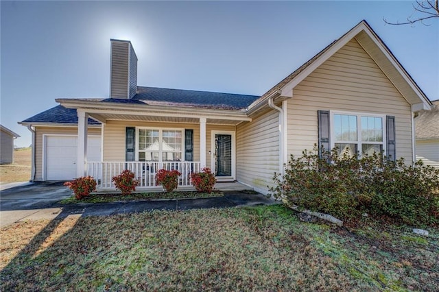 ranch-style house with covered porch, concrete driveway, an attached garage, a shingled roof, and a chimney