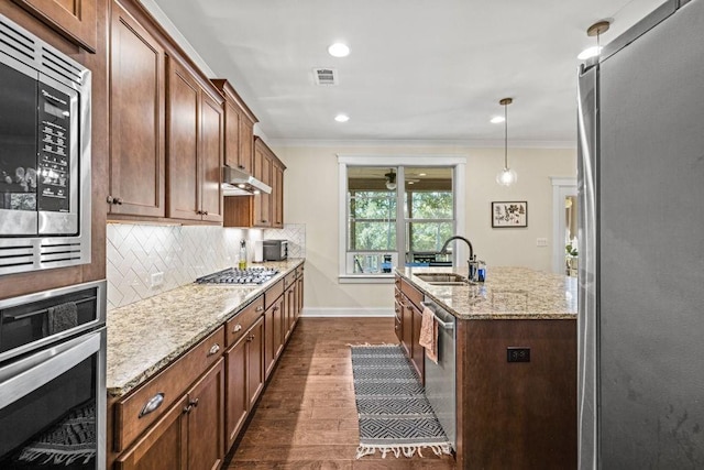 7143 Lake Edge Dr, Flowery Branch, GA 30542 - kitchen with a sink, under cabinet range hood, visible vents, ornamental molding, and appliances with stainless steel finishes