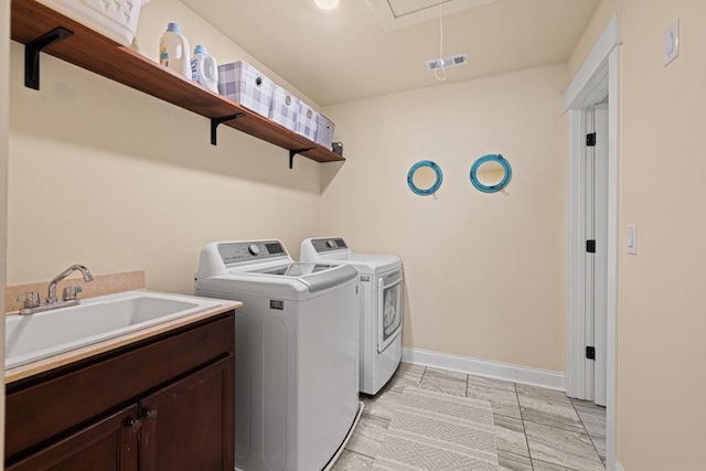 7143 Lake Edge Dr, Flowery Branch, GA 30542 - laundry area featuring a sink, baseboards, attic access, washer and dryer, and cabinet space