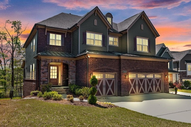 7143 Lake Edge Dr, Flowery Branch, GA 30542 - view of front facade with a yard, brick siding, a standing seam roof, concrete driveway, and an attached garage