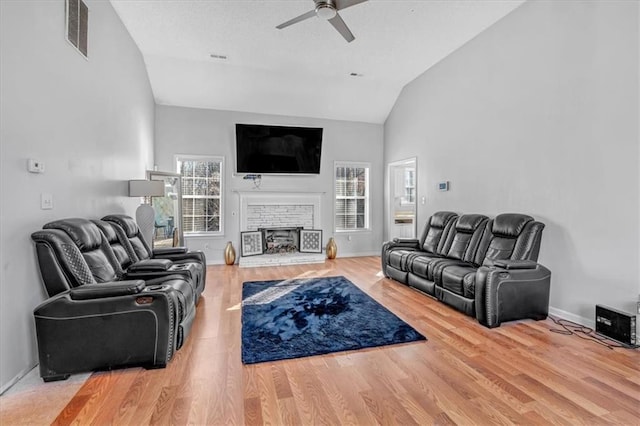 living room with hardwood / wood-style flooring, ceiling fan, and vaulted ceiling