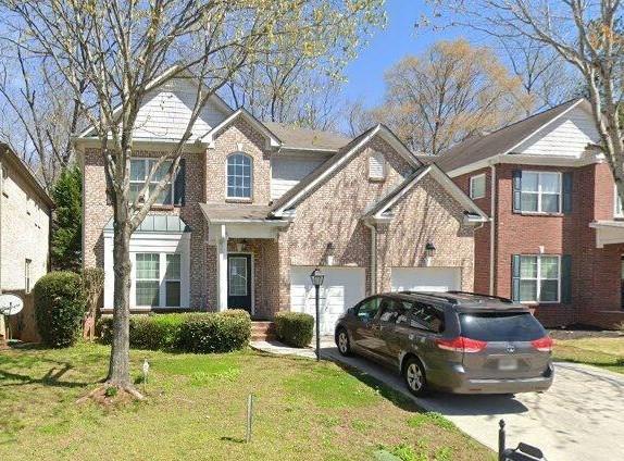 view of front of home featuring a front yard, concrete driveway, and brick siding