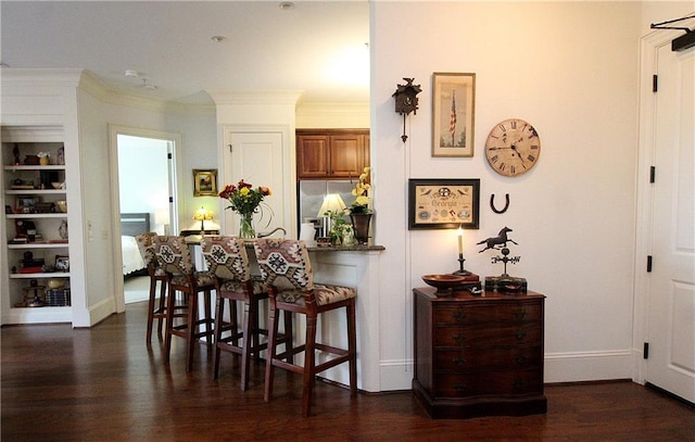 interior space featuring ornamental molding, built in features, and dark hardwood / wood-style flooring