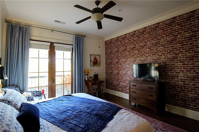 bedroom with crown molding, brick wall, dark wood-type flooring, and ceiling fan