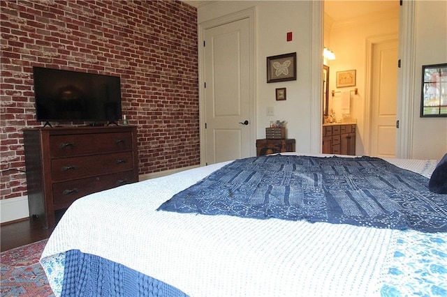 bedroom featuring ornamental molding, brick wall, and wood-type flooring