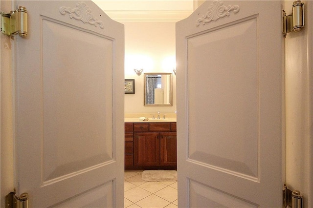 bathroom with tile patterned flooring, vanity, and crown molding