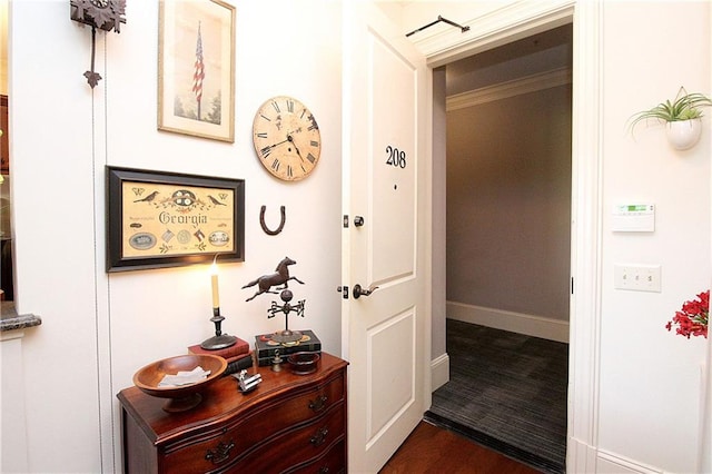 hallway with ornamental molding and dark hardwood / wood-style flooring