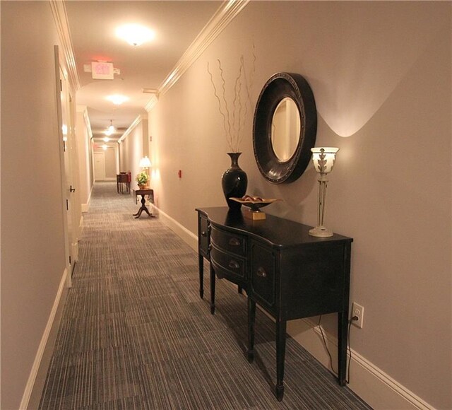 hall featuring crown molding and dark carpet