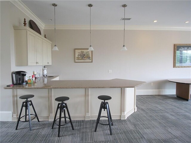 kitchen with sink, a breakfast bar area, and pendant lighting