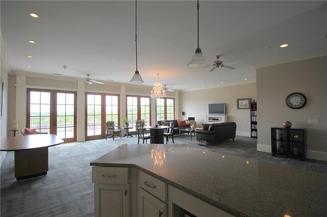 kitchen with ceiling fan, ornamental molding, carpet floors, and hanging light fixtures