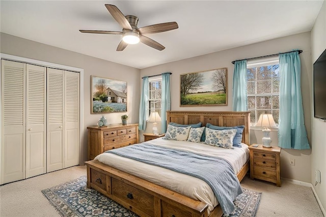 bedroom featuring ceiling fan, light carpet, and a closet