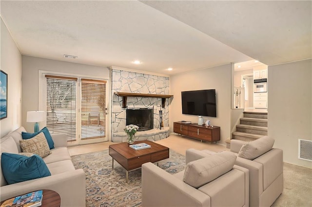 living room with a stone fireplace and light colored carpet