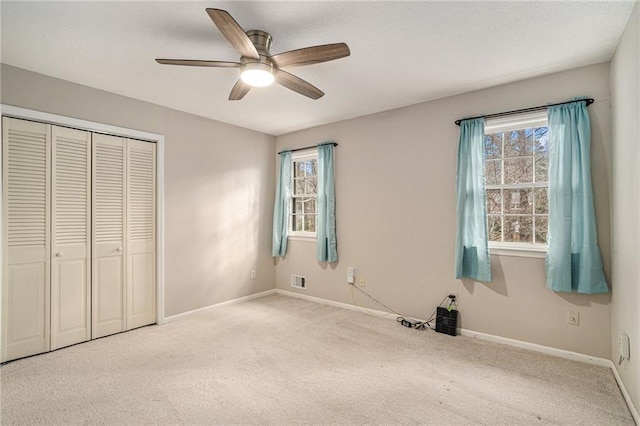 unfurnished bedroom featuring carpet flooring, ceiling fan, and a closet