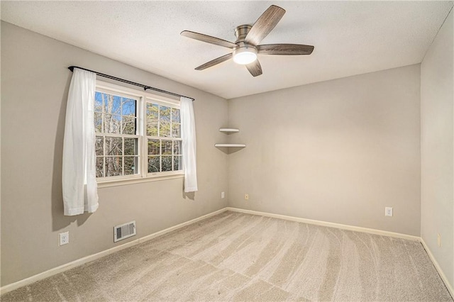 empty room with light carpet, a textured ceiling, and ceiling fan