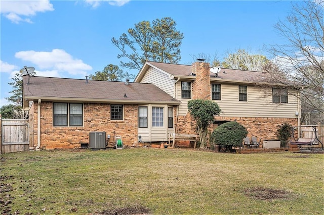 rear view of property with a yard and central AC