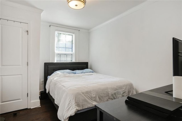 bedroom with dark hardwood / wood-style flooring and crown molding