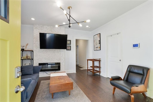 living room featuring a fireplace, ornamental molding, dark hardwood / wood-style floors, and a chandelier